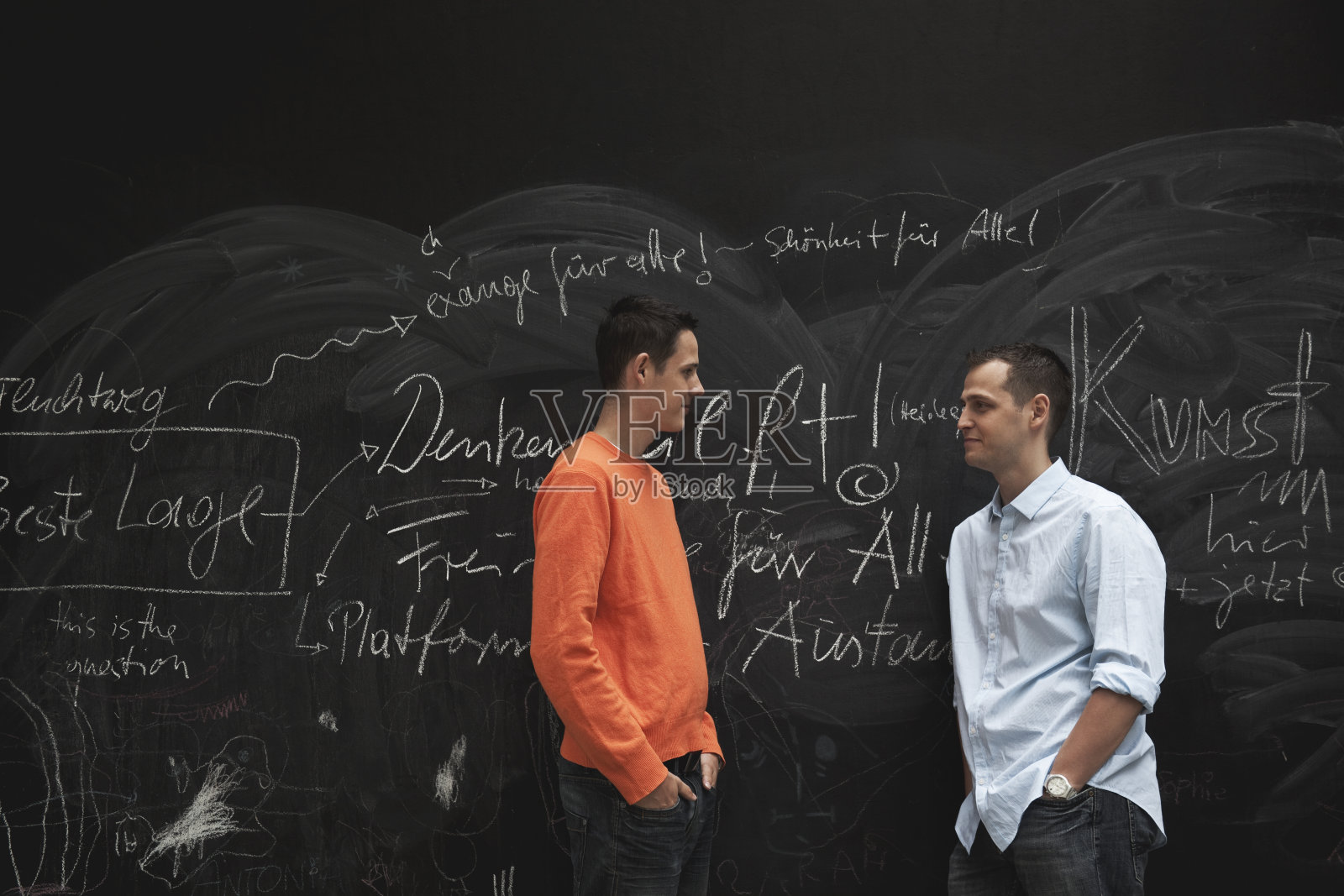 德国，柏林，两个人靠着黑板站着照片摄影图片