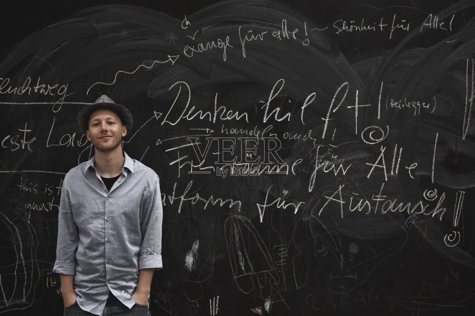 德国，柏林，男人站在黑帽旁，肖像照片摄影图片