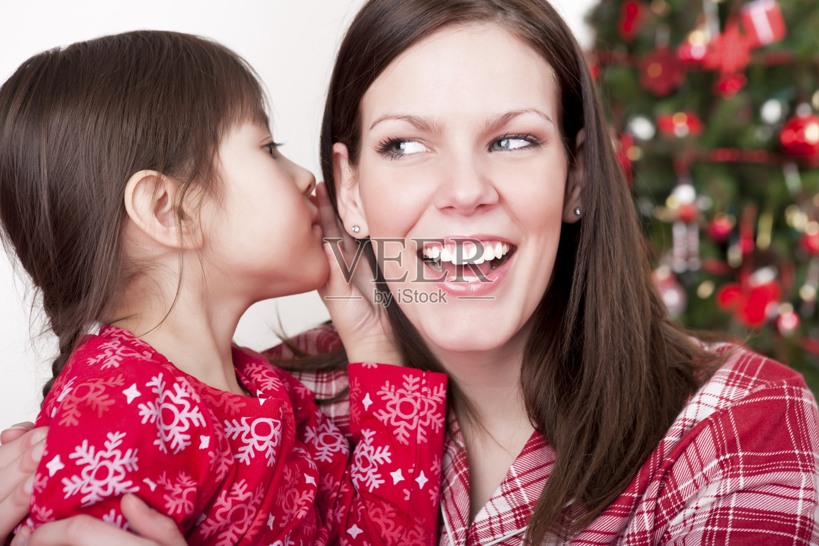 圣诞女人听着女儿的微笑照片摄影图片