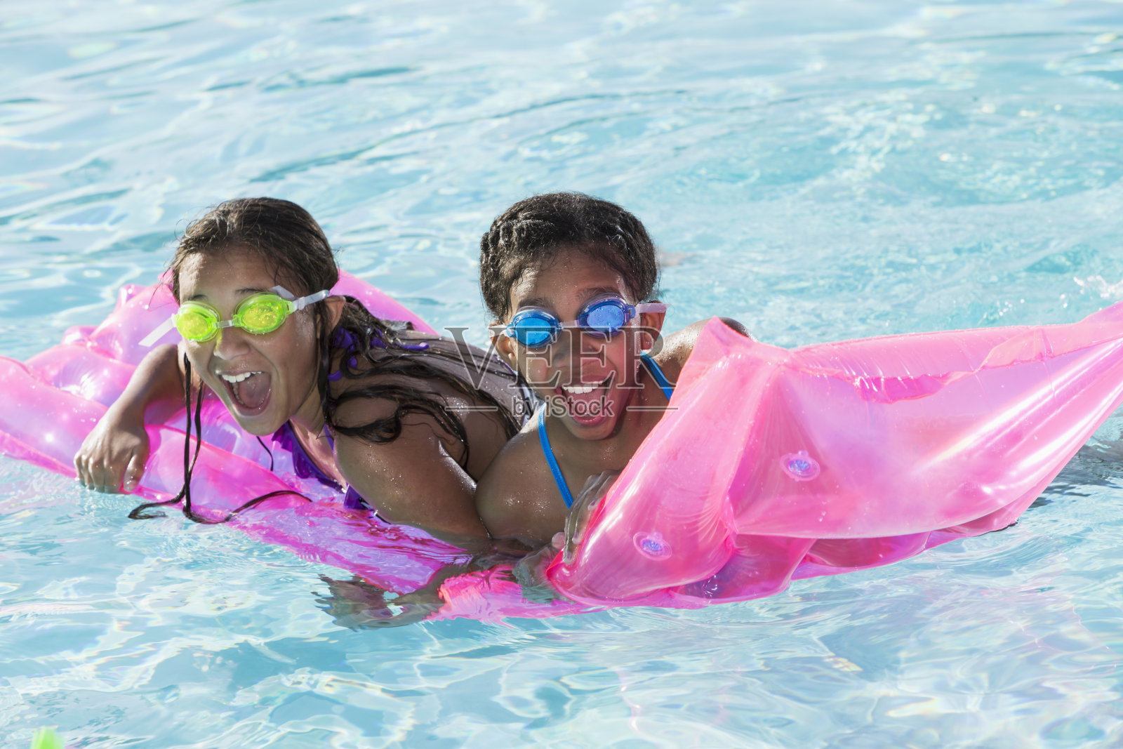 女孩们在游泳池里玩。照片摄影图片