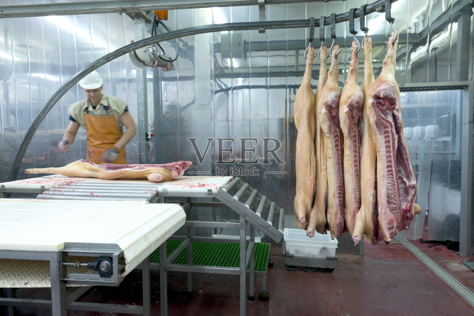 在食品加工厂切肉的屠夫照片摄影图片