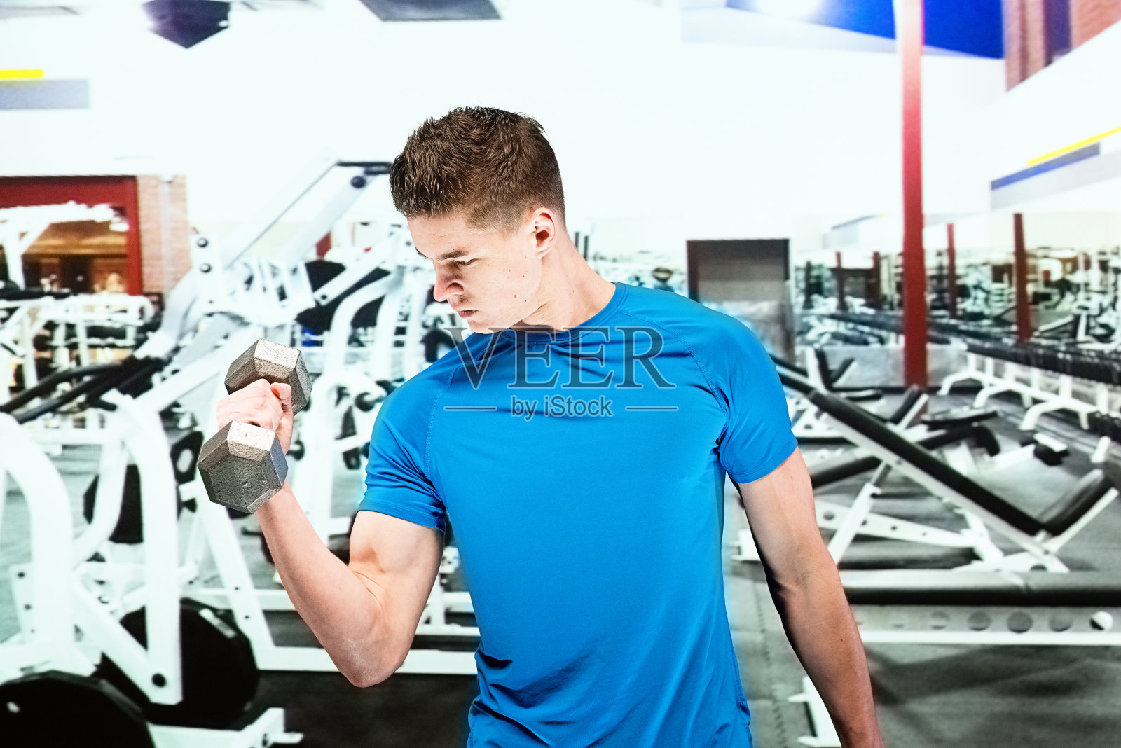 男性在健身房用哑铃锻炼照片摄影图片