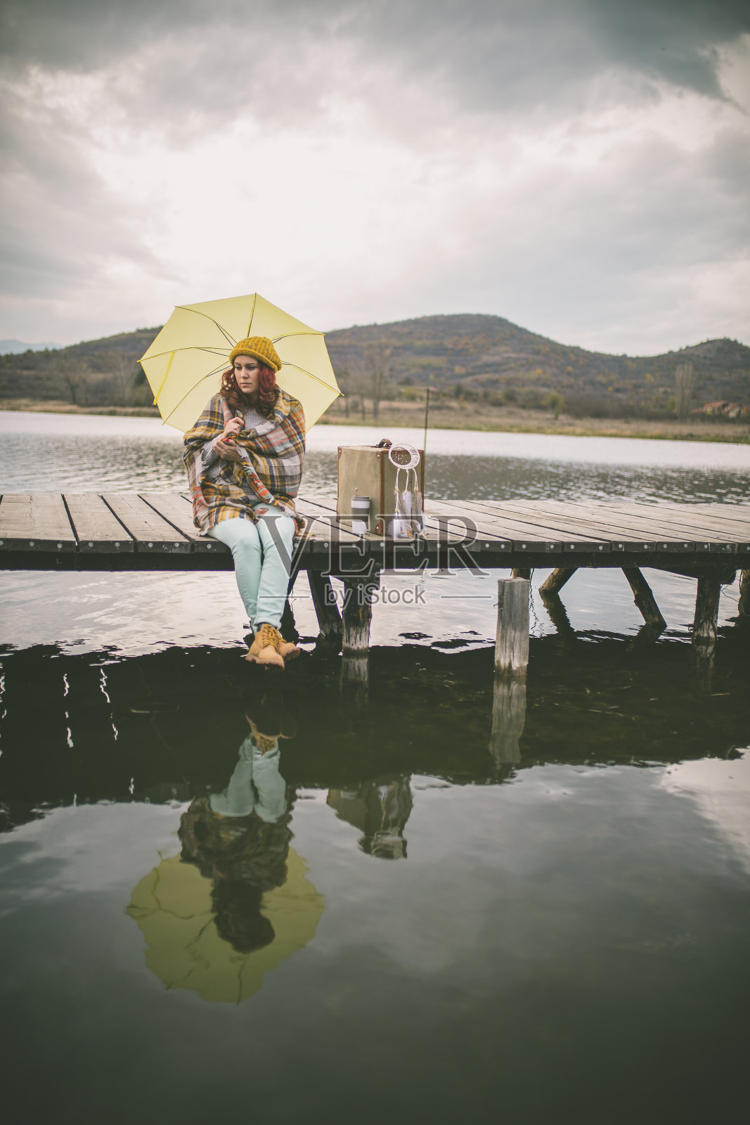 女人拿着伞在河边码头等着照片摄影图片