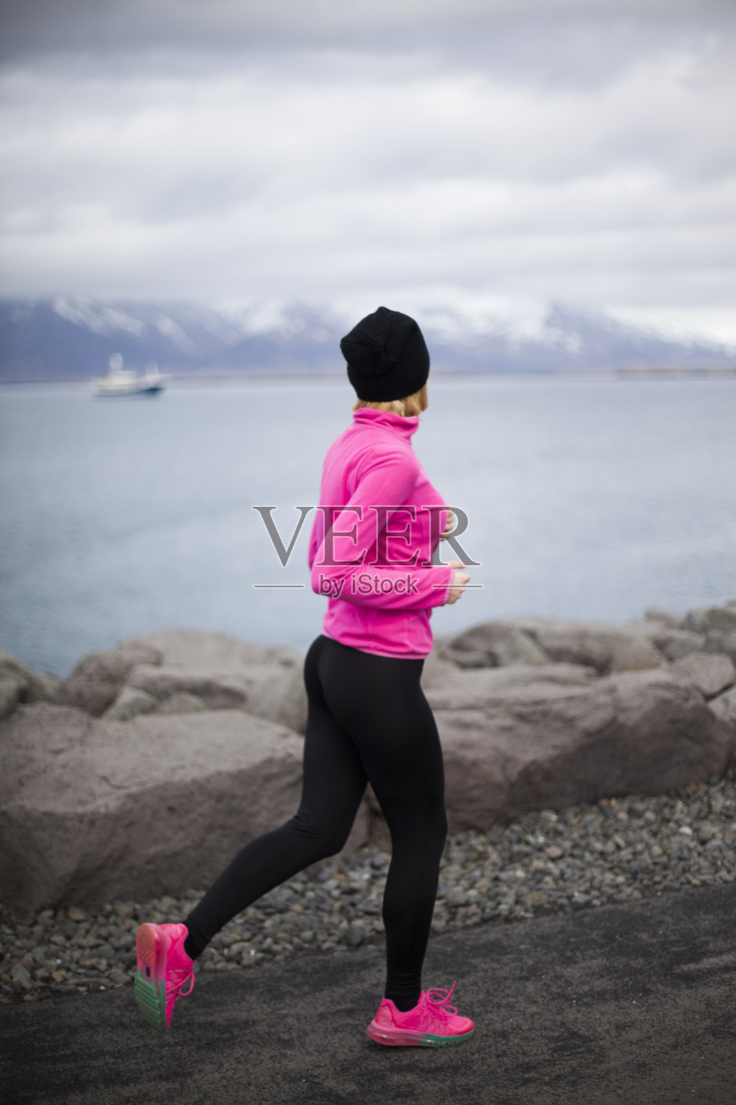 在冰岛奔跑的年轻女子运动员。照片摄影图片