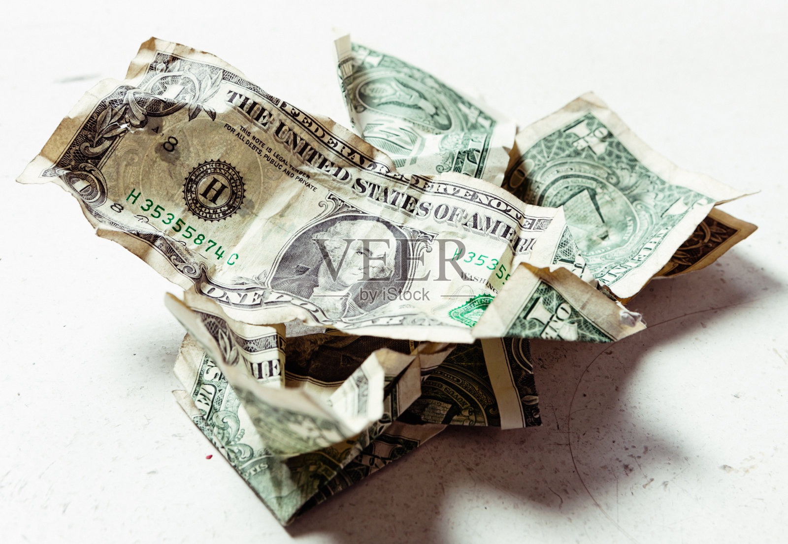 皱巴巴的、被丢弃的、脏兮兮的美钞在凌乱的表面上照片摄影图片