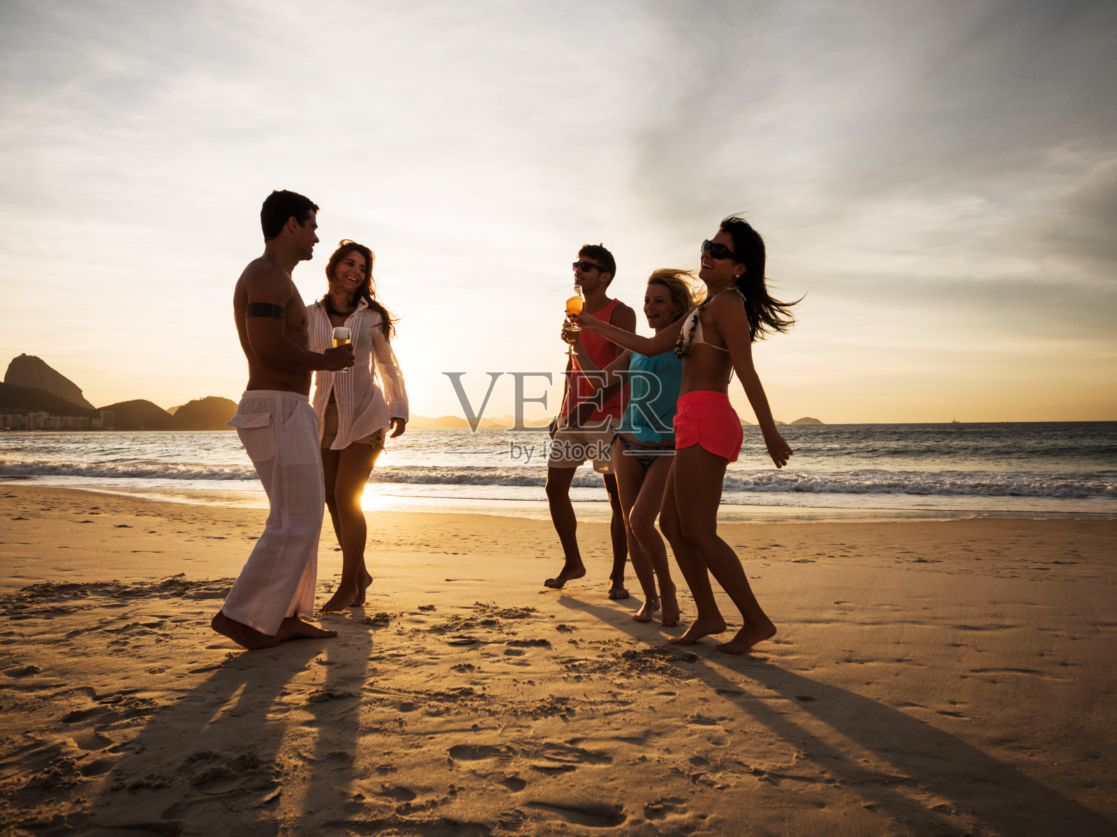 日落时的海滩派对。照片摄影图片