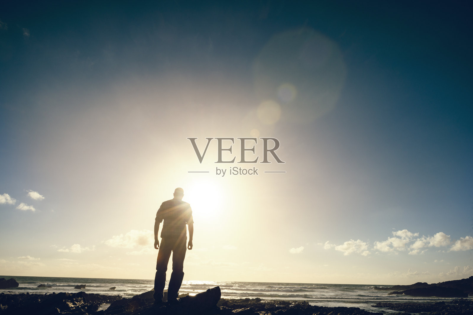 在小菲斯特海滩傍晚的阳光下背光的男人照片摄影图片