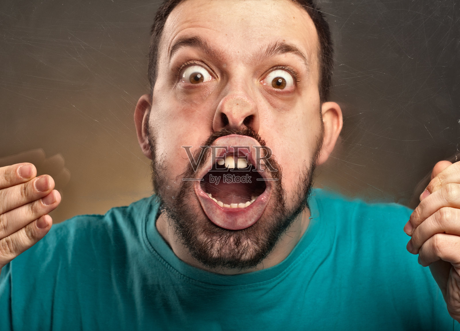 一个人吹着玻璃做鬼脸照片摄影图片