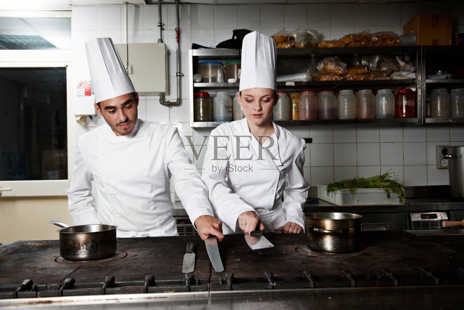 两个厨师在柜台上挑选刀具照片摄影图片