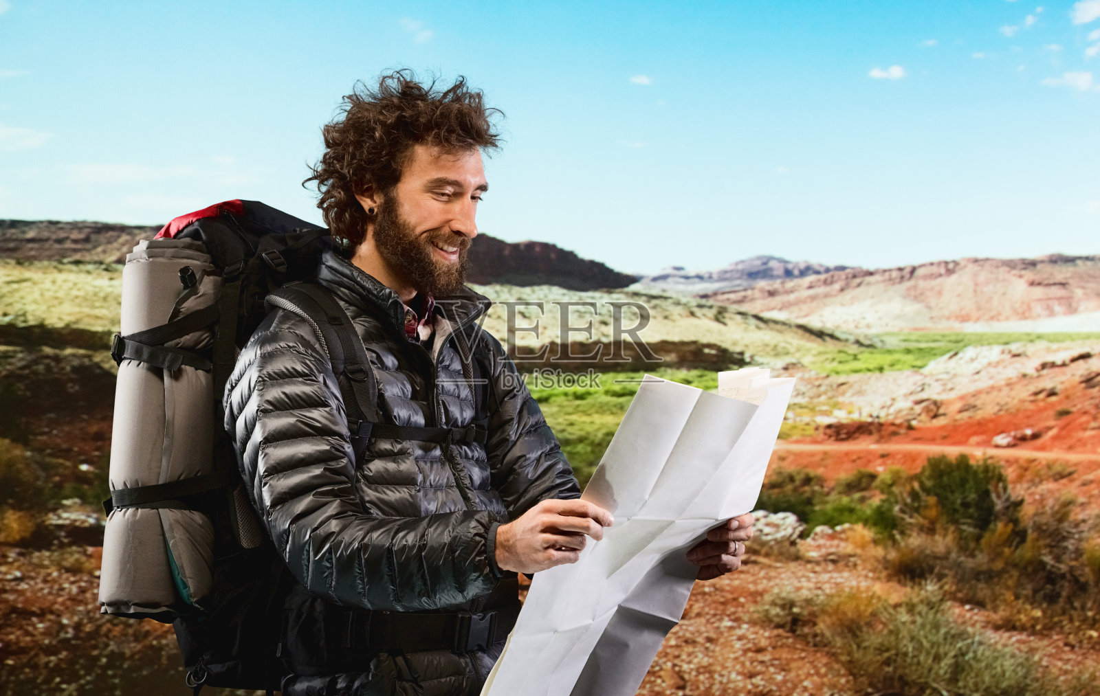 在沙漠中拿着地图的徒步旅行者照片摄影图片