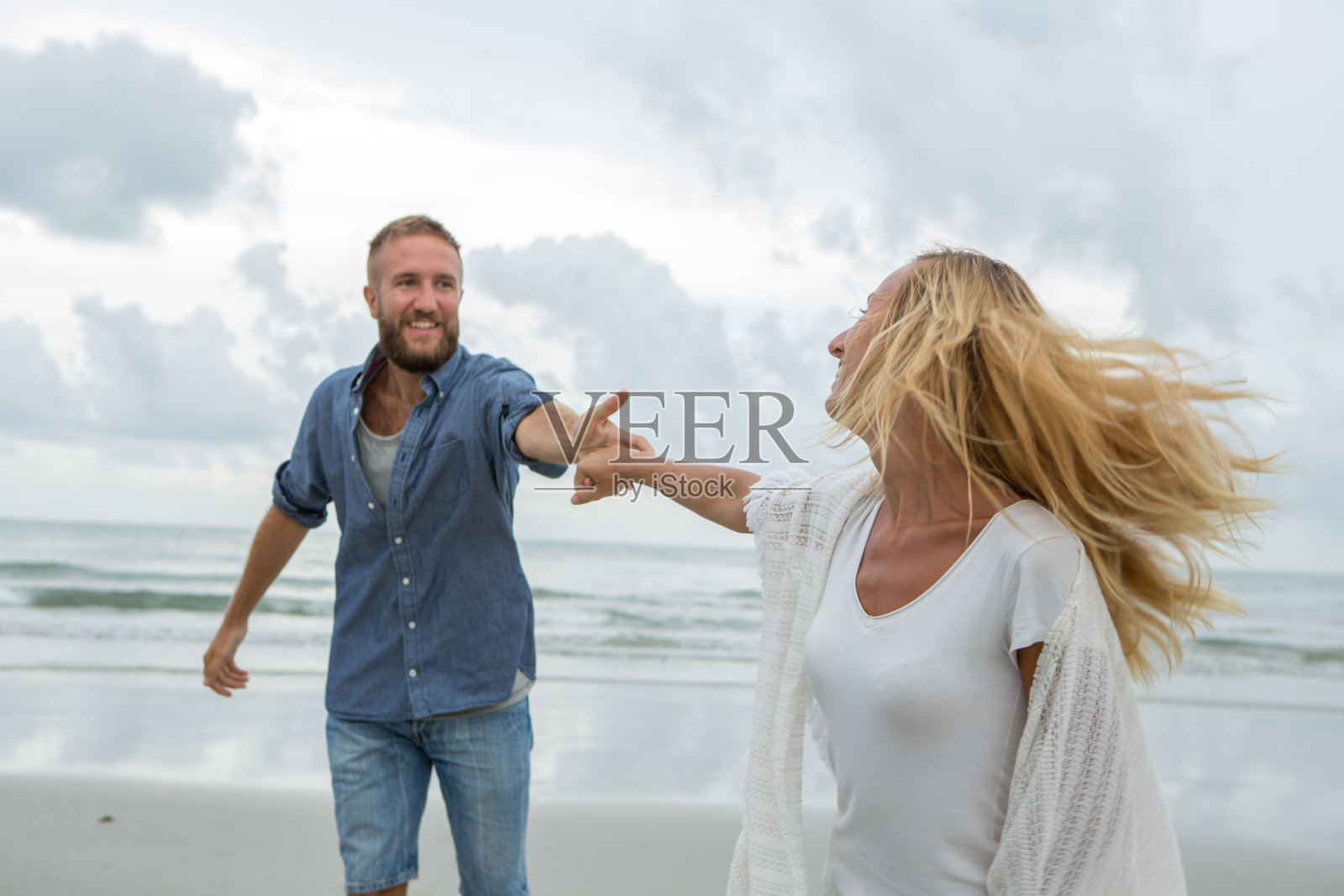 在海滩上奔跑的年轻夫妇照片摄影图片