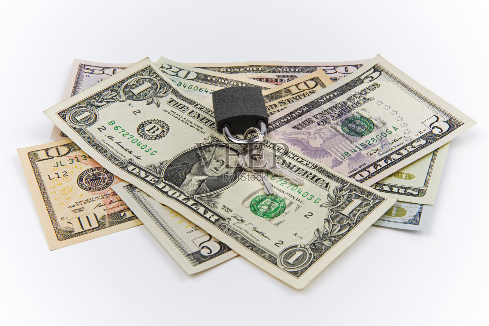 安全的钱。锁在一堆美钞上。照片摄影图片