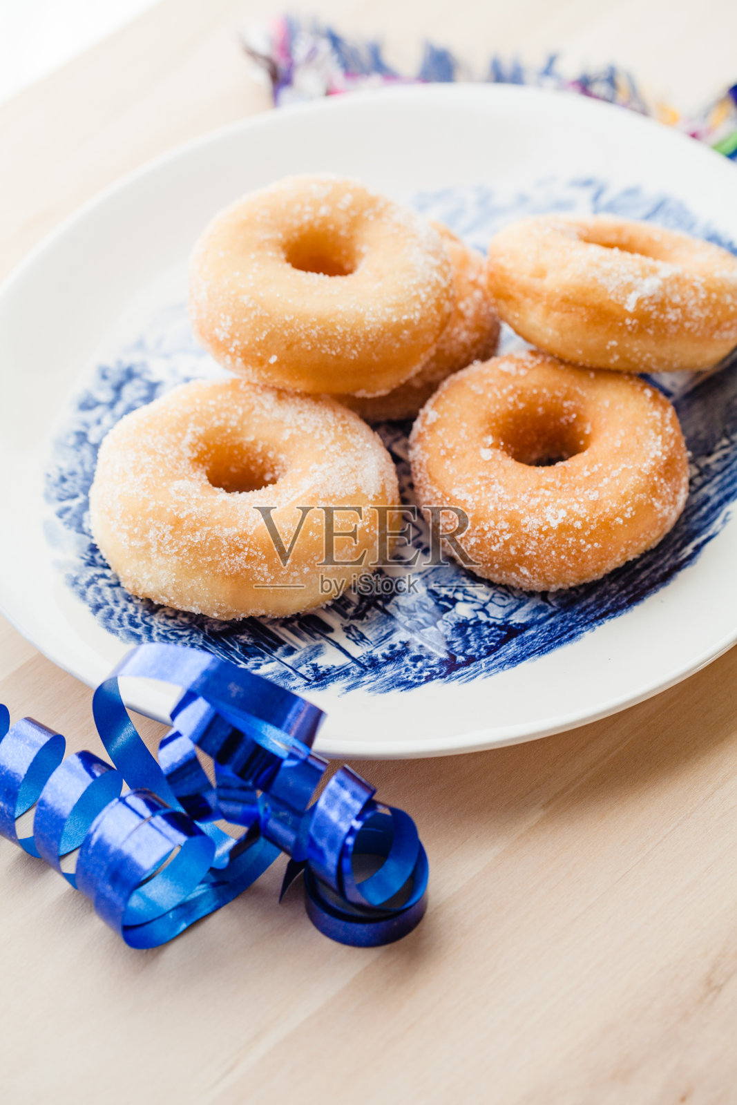 盘子里放上撒了糖的甜甜圈照片摄影图片
