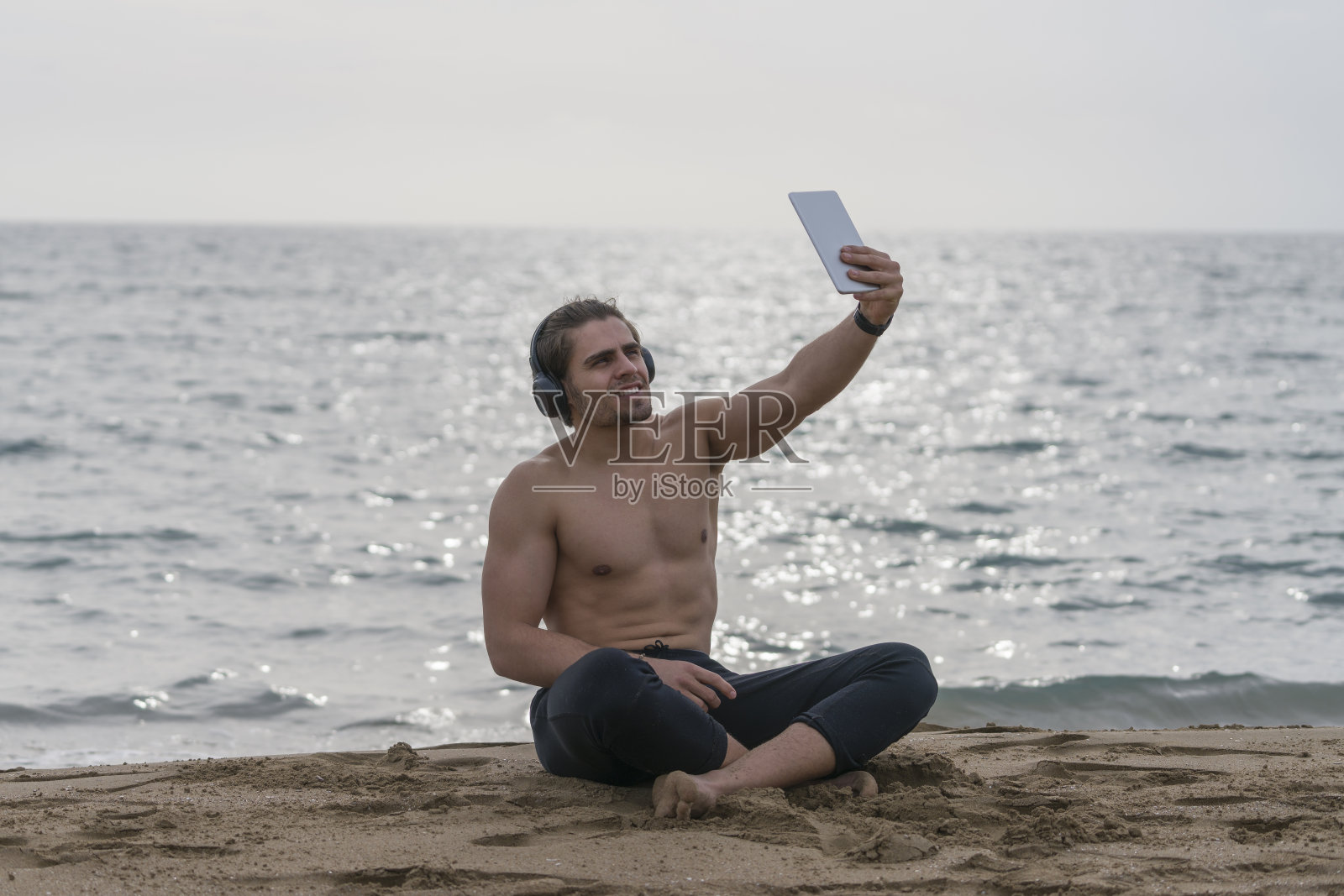 英俊的男人独自在海滩上休息照片摄影图片