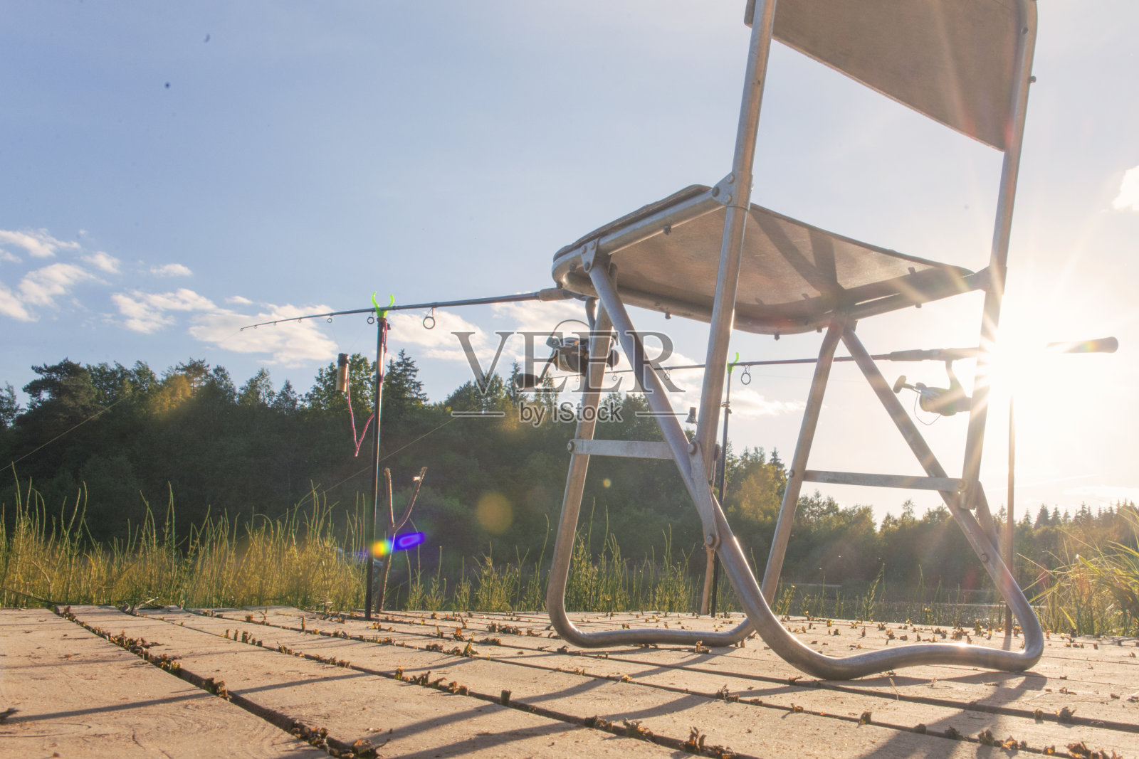 钓竿竖立在抛入水中用于钓鱼的支撑物上的钓竿照片摄影图片