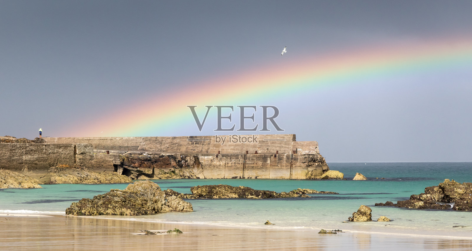 闪亮的彩虹越过海港和海滩照片摄影图片