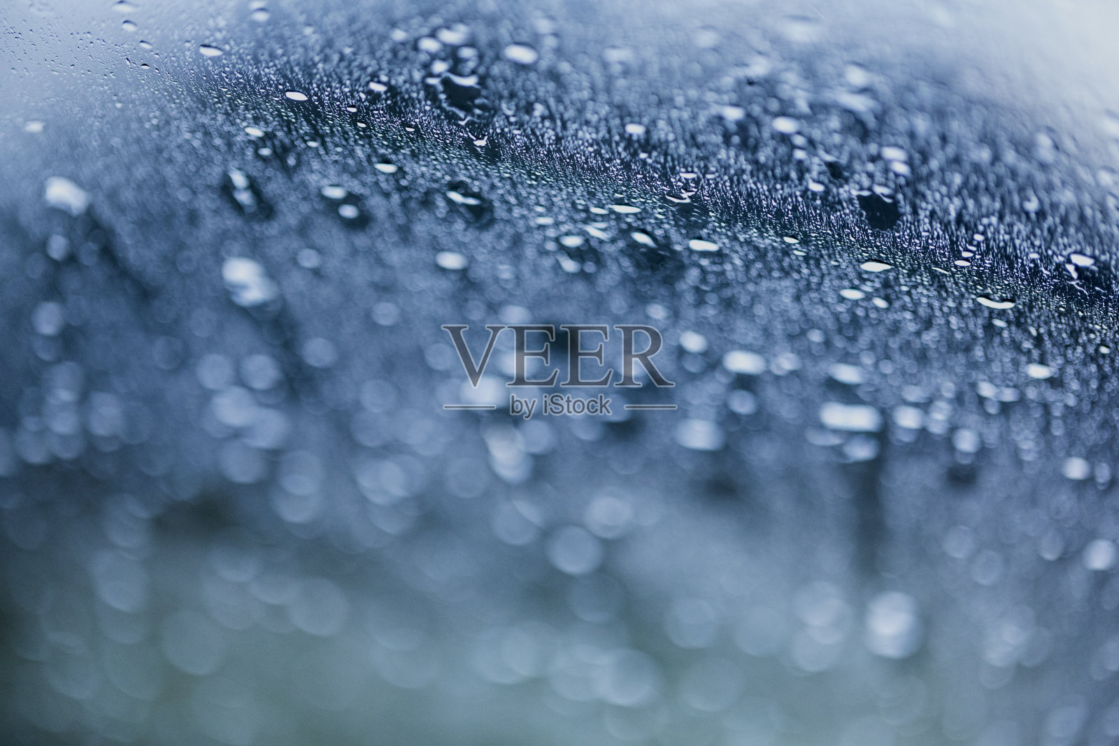 雨的背景如同透过车窗的一辆汽车在运动。照片摄影图片