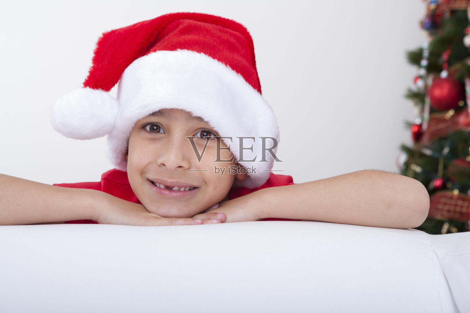 戴着圣诞帽的圣诞微笑男孩照片摄影图片
