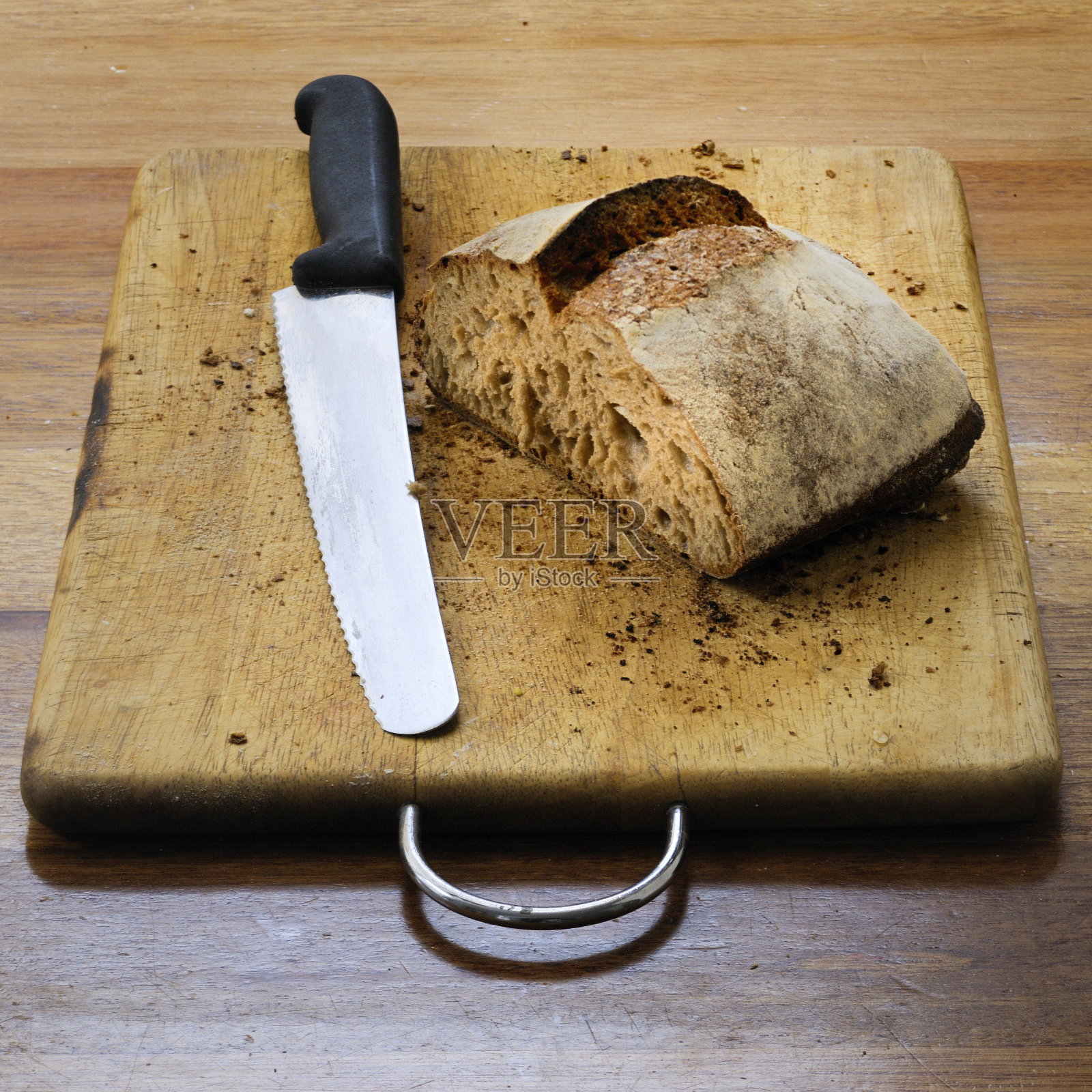 全麦面包和切菜板上的刀照片摄影图片