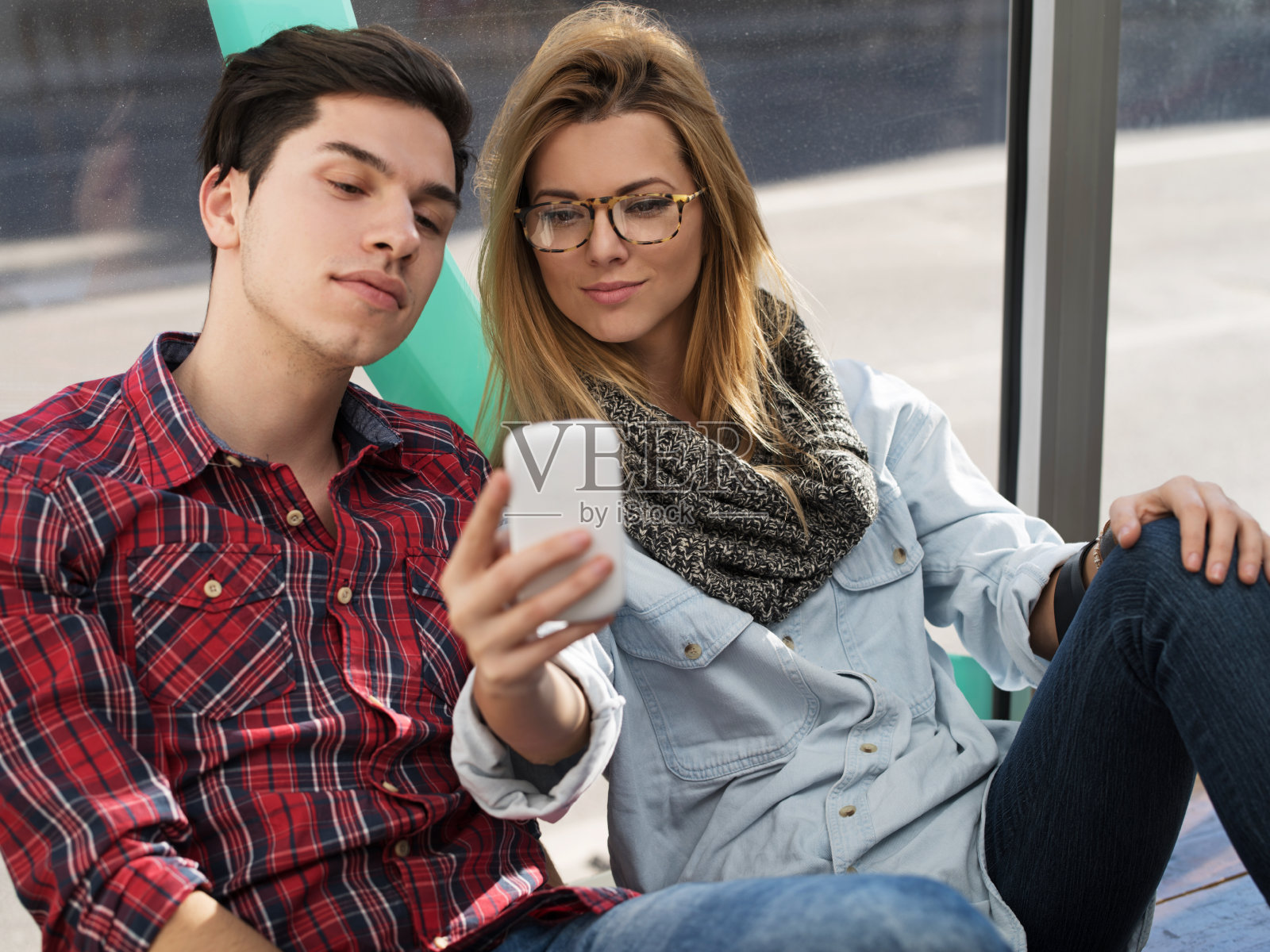 年轻夫妇享受在一起和使用手机。照片摄影图片