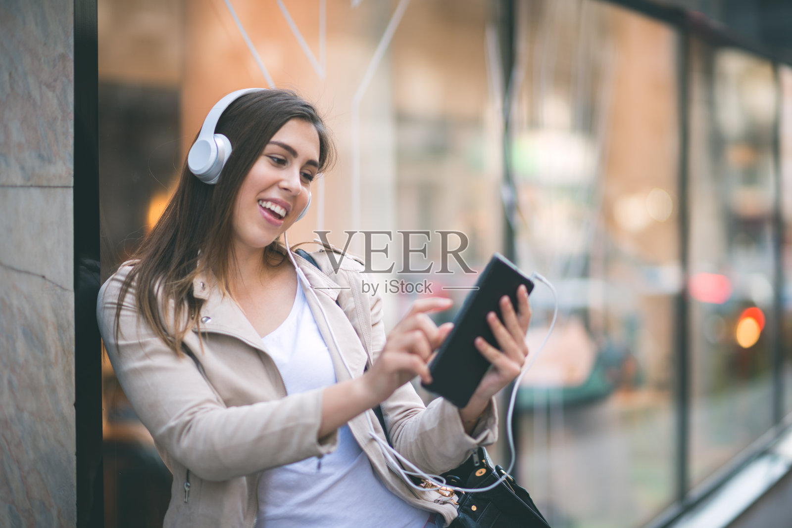 一个十几岁的女孩在街角听音乐照片摄影图片