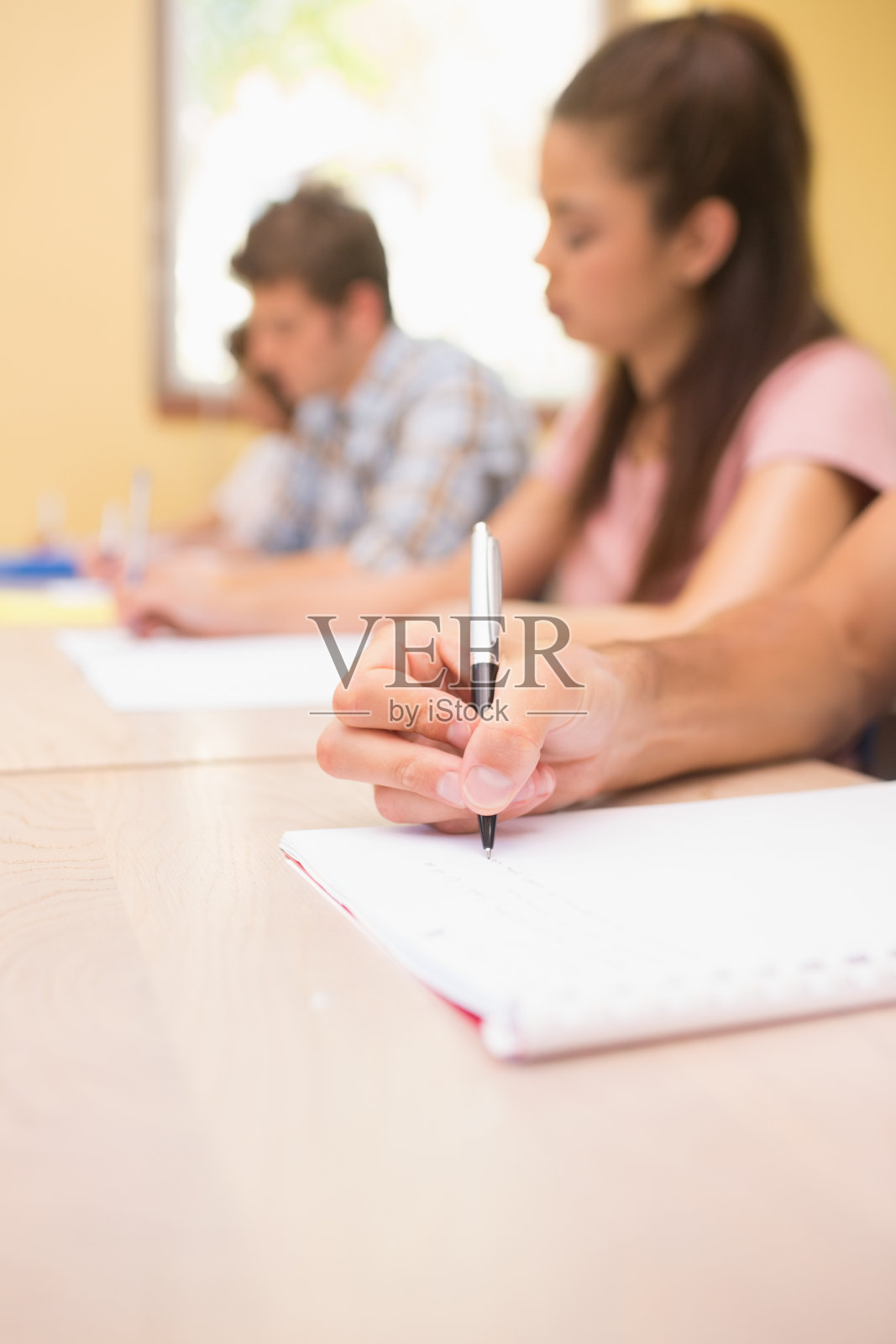 学生在课桌上写书照片摄影图片