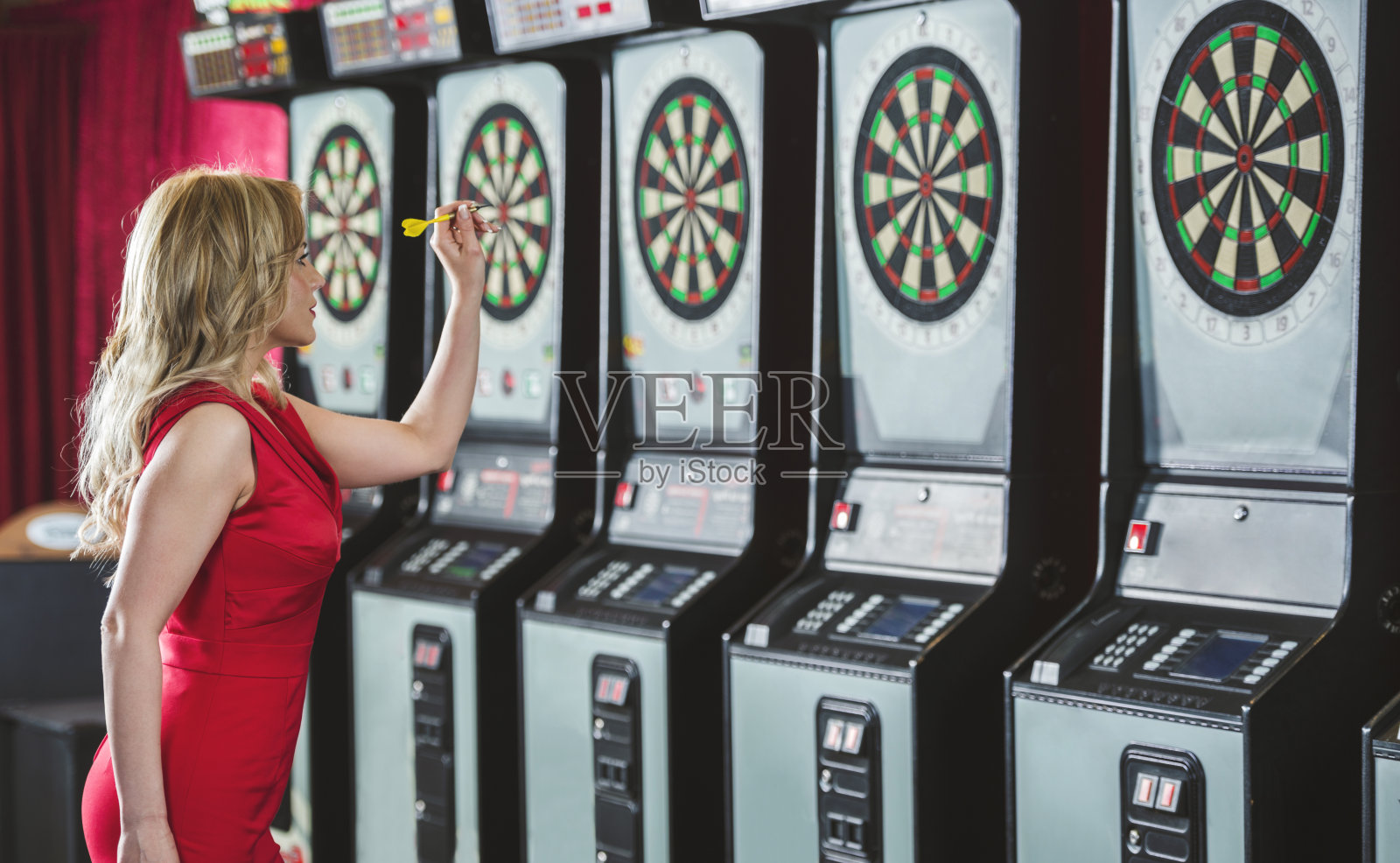 一个玩飞镖的女人的侧面。照片摄影图片