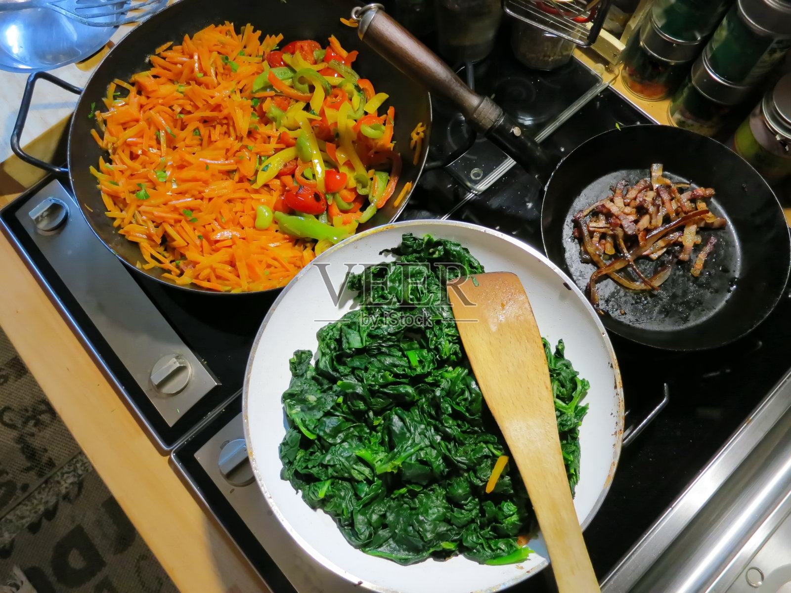 自制菠菜，卡通，煎锅里的煤气炉上的煎培根。照片摄影图片