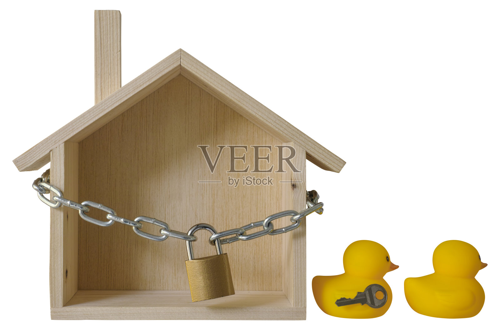 概念木屋用挂锁和铁链包裹着，两只黄色的橡皮鸭子用钥匙离开了锁着的房子。照片摄影图片