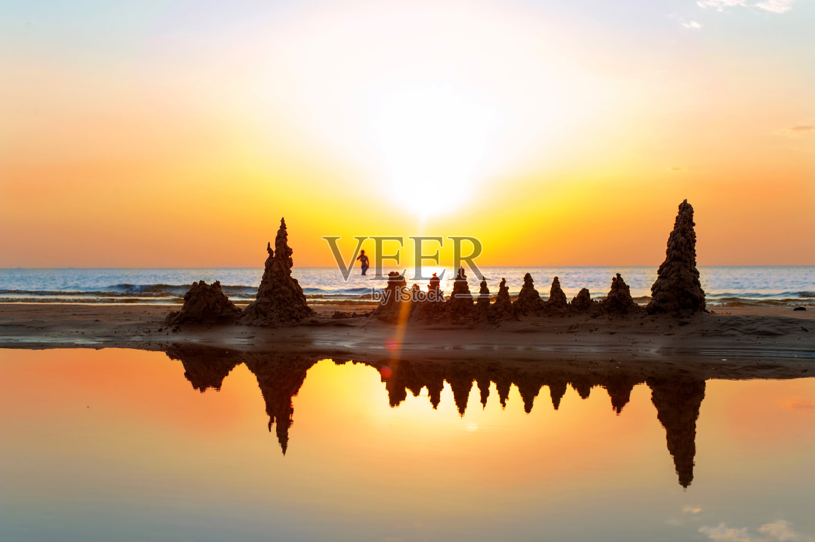 海滩与沙堡在壮观的波罗的海日落背景。照片摄影图片