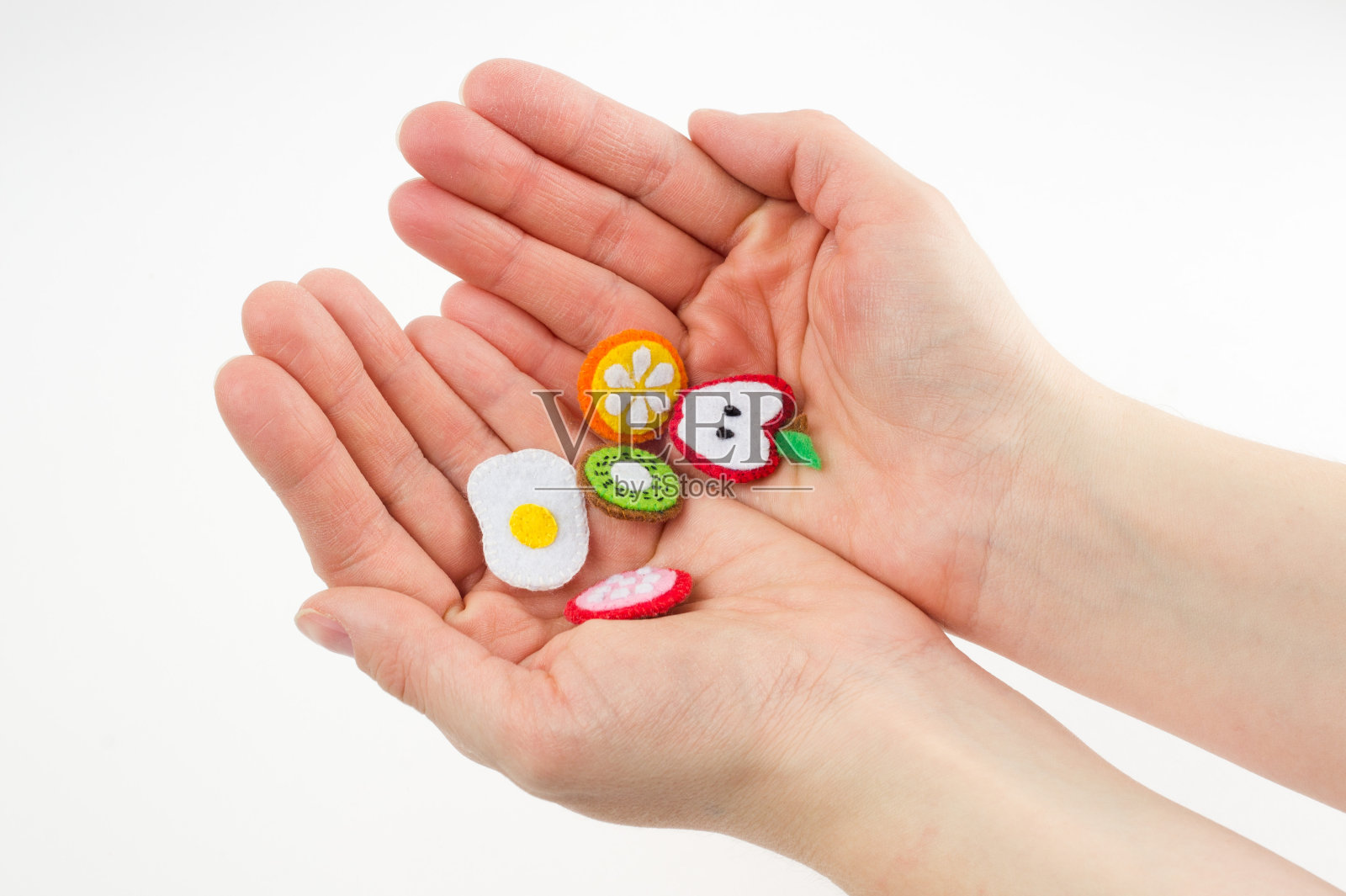 手工制作的水果和食物玩具，用毡制成，放在手掌上。手绣工艺品的特写照片摄影图片