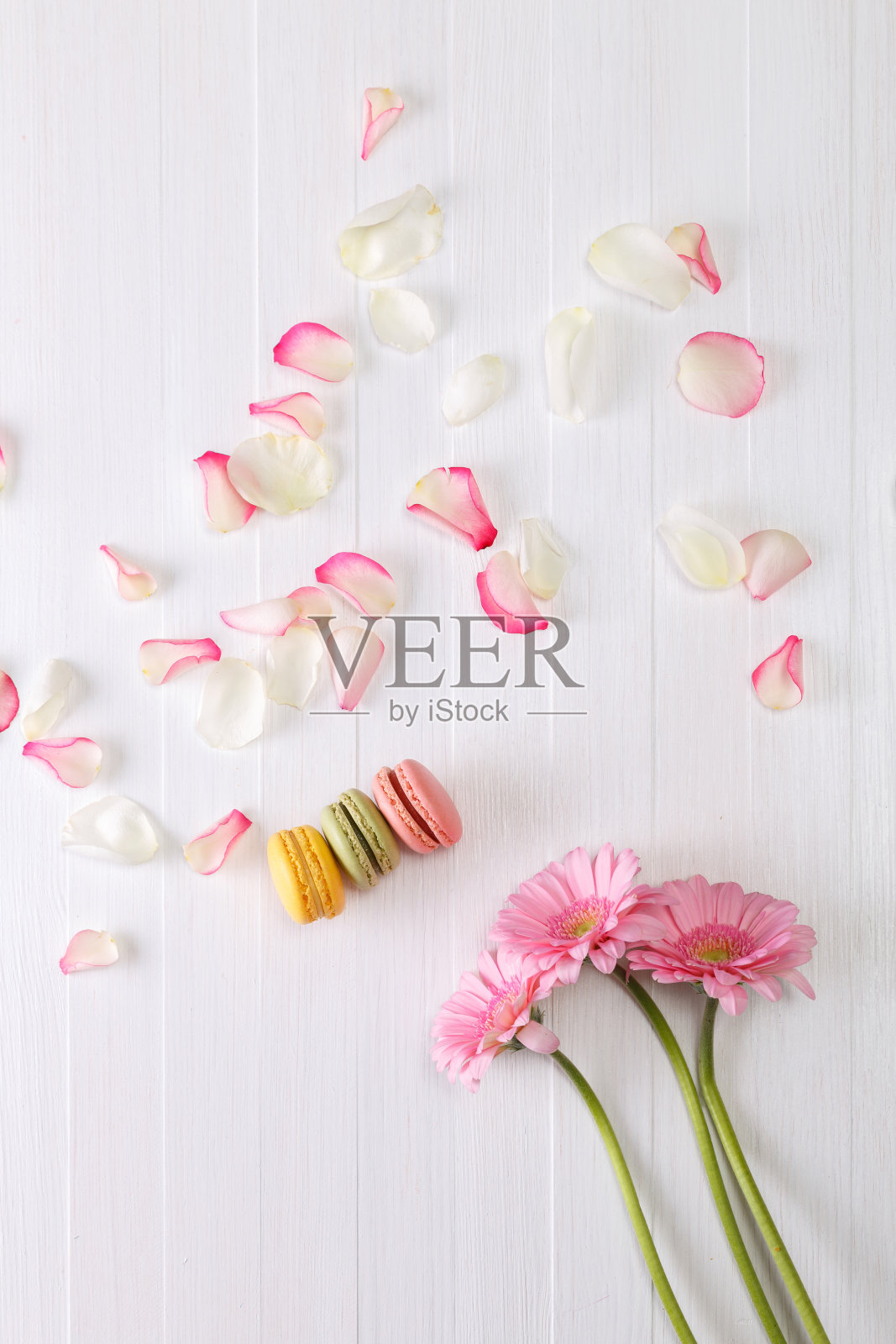 带有粉色非洲菊花的马卡龙蛋糕。照片摄影图片