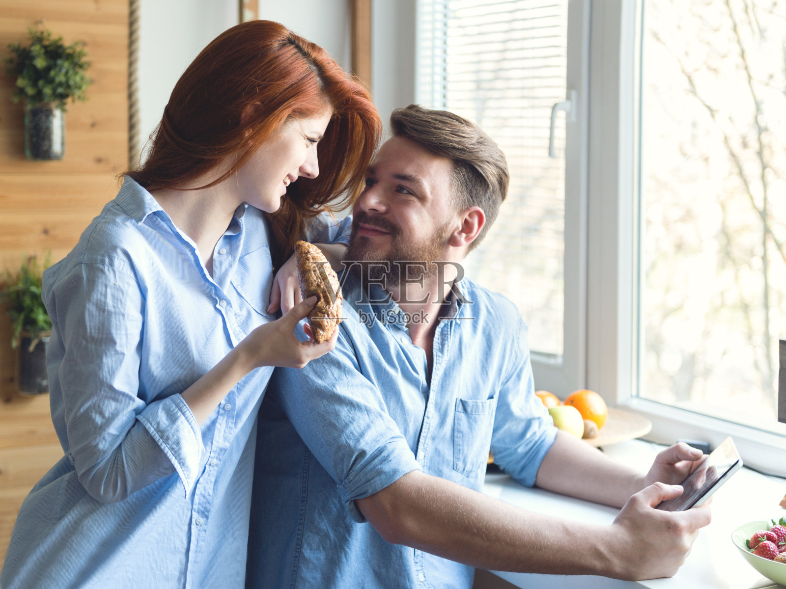 愉快的年轻夫妇享用早餐，使用平板电脑照片摄影图片