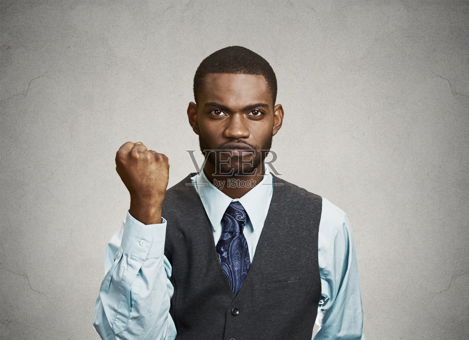 生气暴躁心烦的年轻人，工人企业员工举起了拳头照片摄影图片