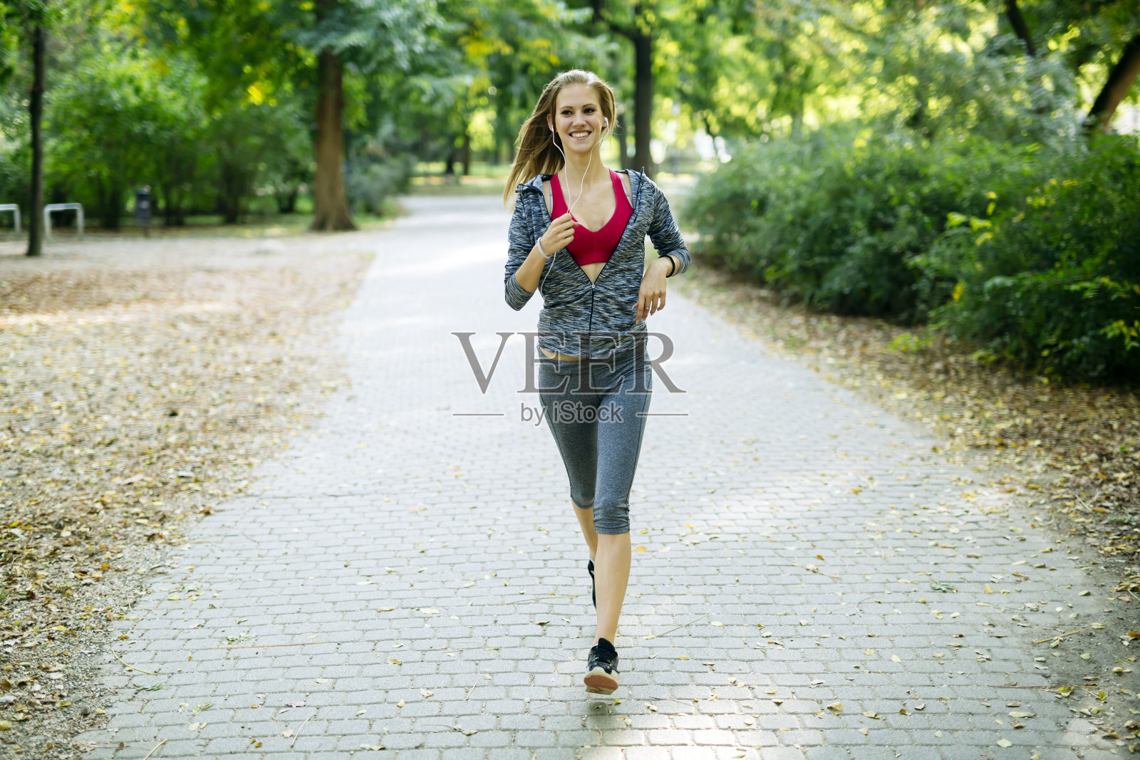 年轻的金发女子在公园慢跑照片摄影图片