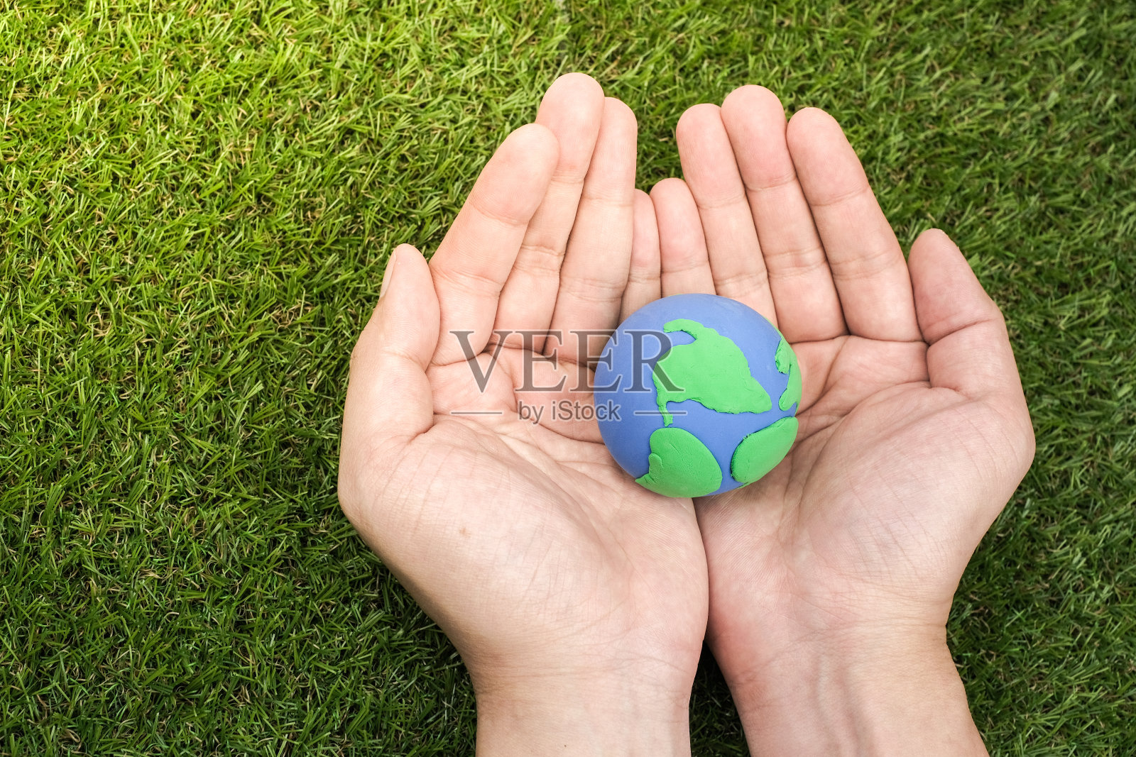 地球，在绿色背景上用粘土制成的泥土。保护绿色地球。地球日节日概念照片摄影图片