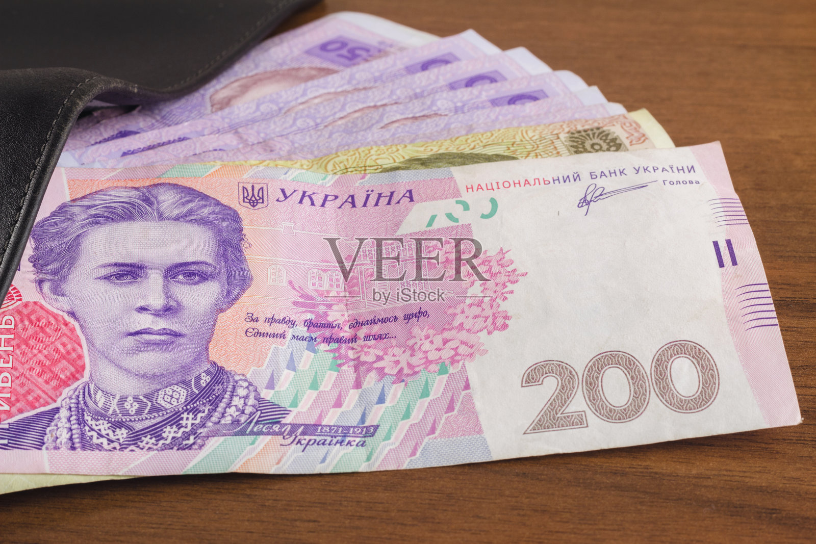 钱包与乌克兰货币格里夫尼亚木制背景。照片摄影图片