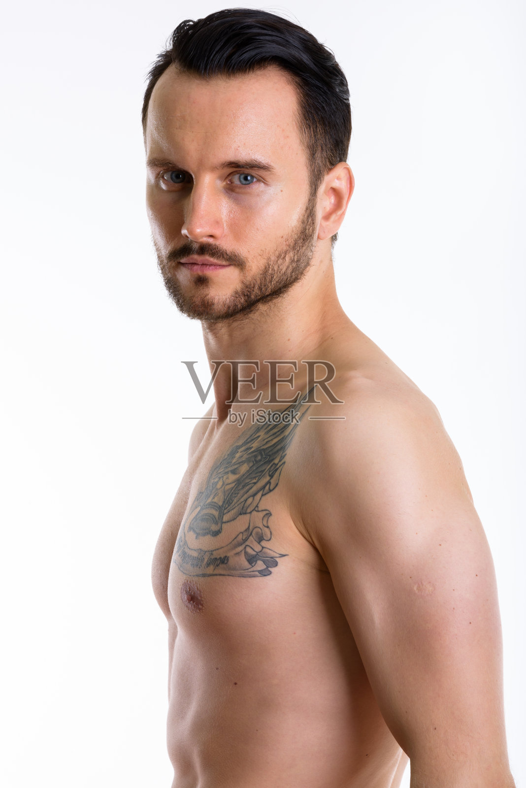 工作室拍摄了一名赤裸上身纹身的年轻人照片摄影图片