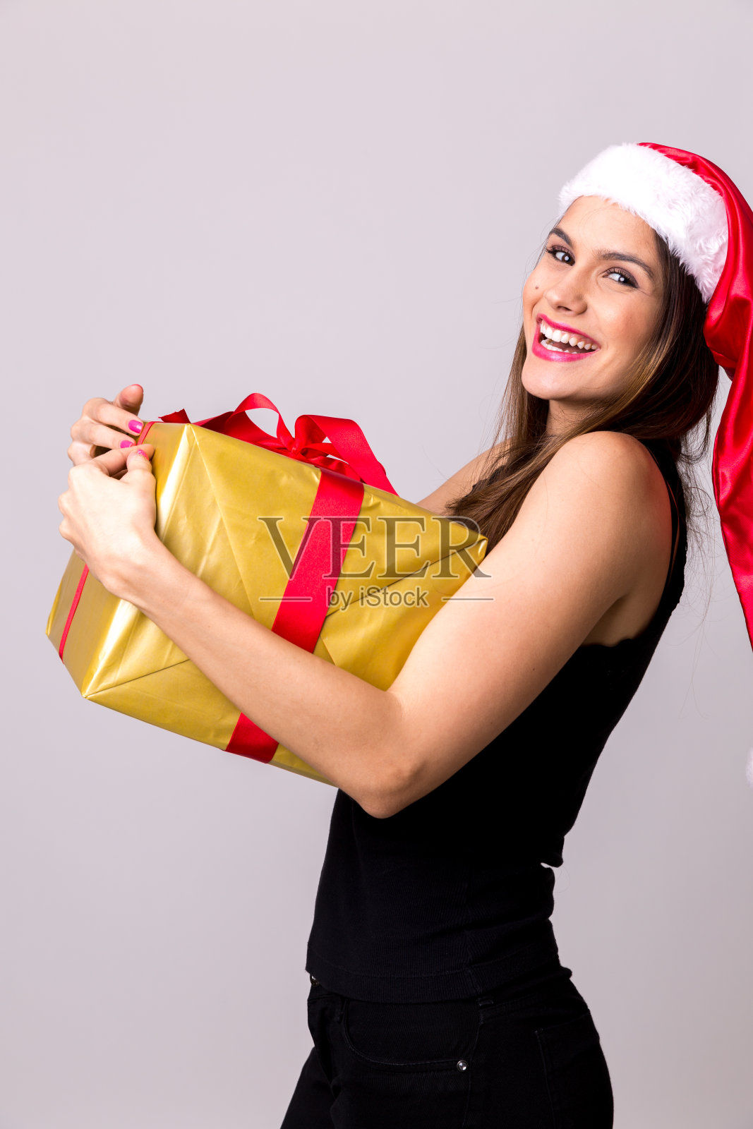 戴圣诞帽的拉丁女孩。圣诞节的主题照片摄影图片