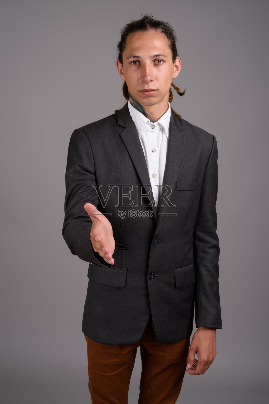 摄影工作室拍摄的年轻商人与灰色背景下的长发绺照片摄影图片