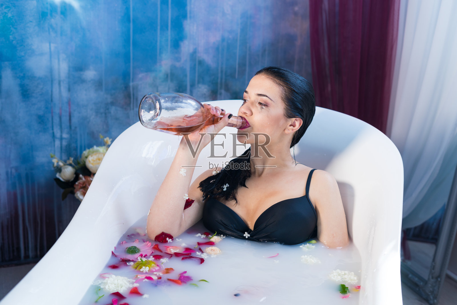 性感的黑发醉醺醺的女人在热水浴中放松照片摄影图片