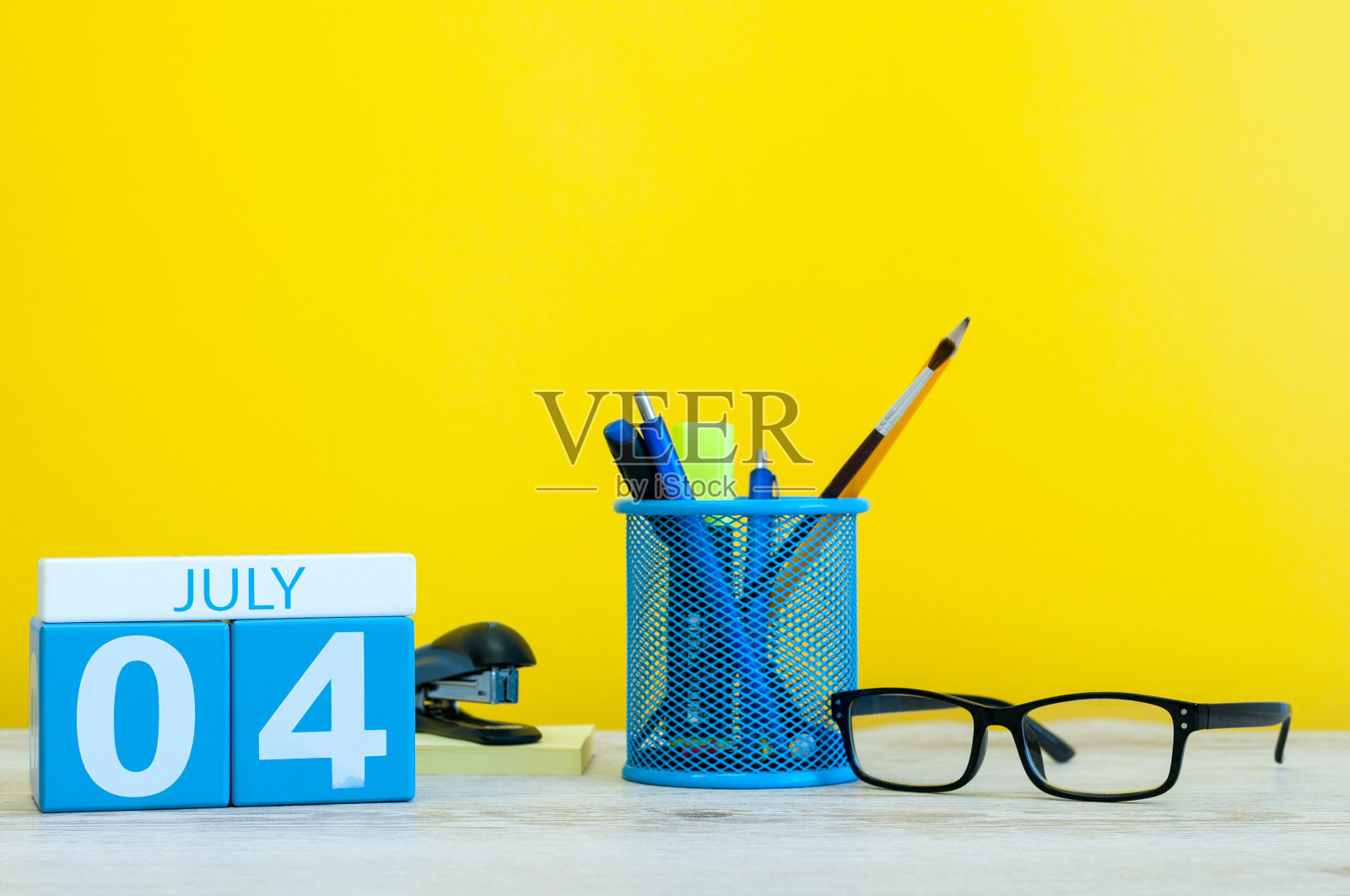 7月4日。7月4日挂历图片，黄色背景，办公用品。夏天的一天。文本的空白。美国独立日照片摄影图片