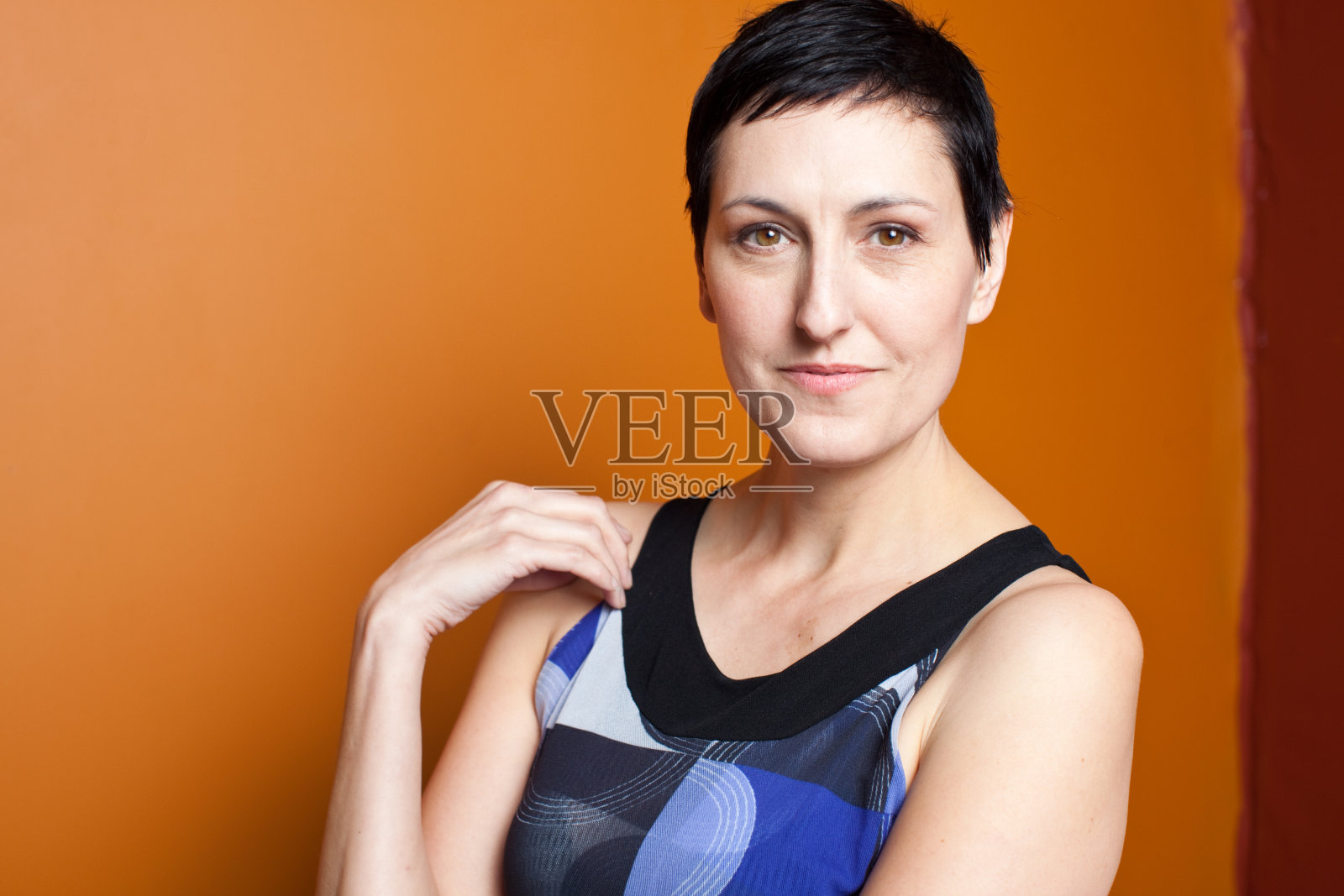 在橙色背景下微笑的女人照片摄影图片