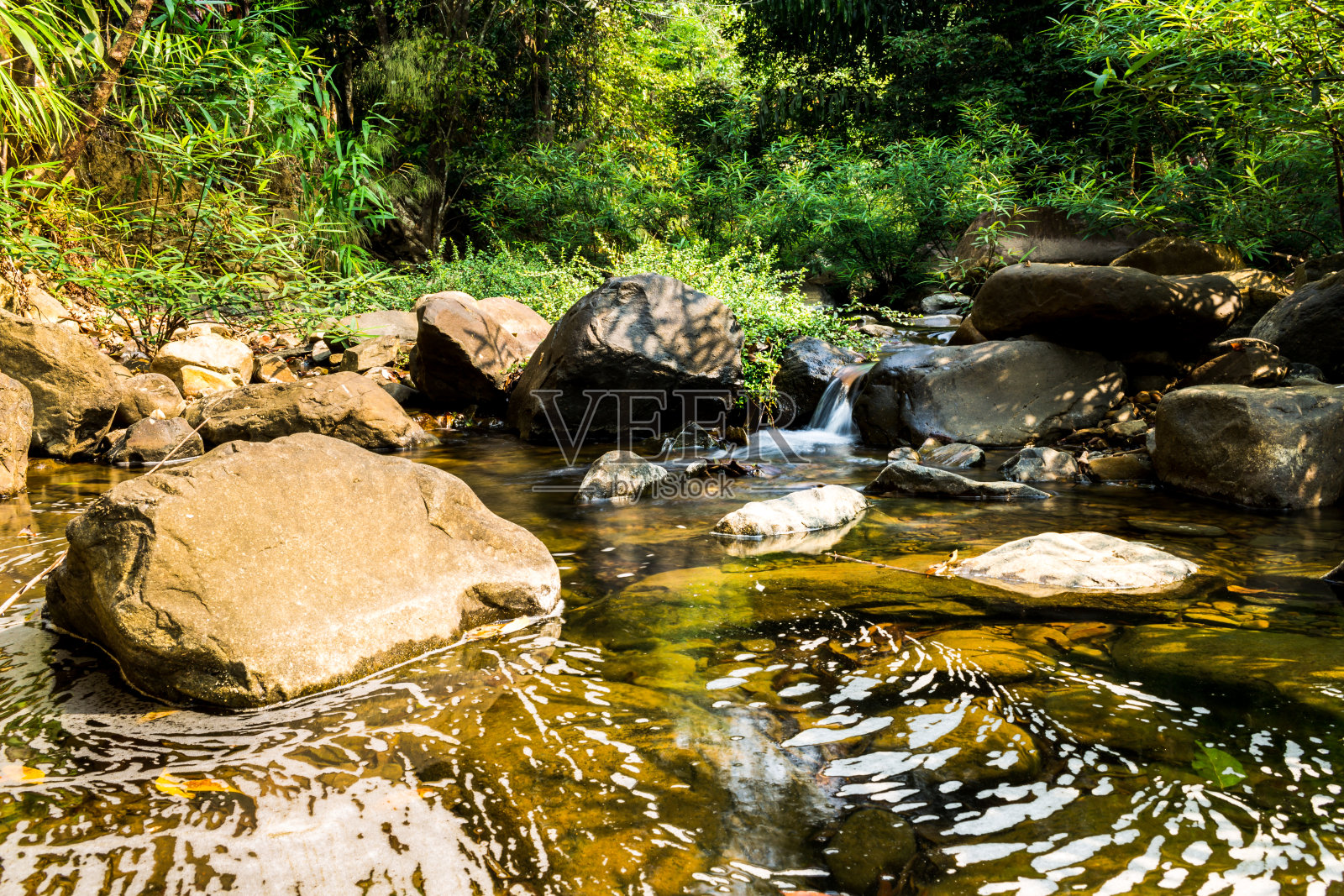 带有自然光的小瀑布。照片摄影图片