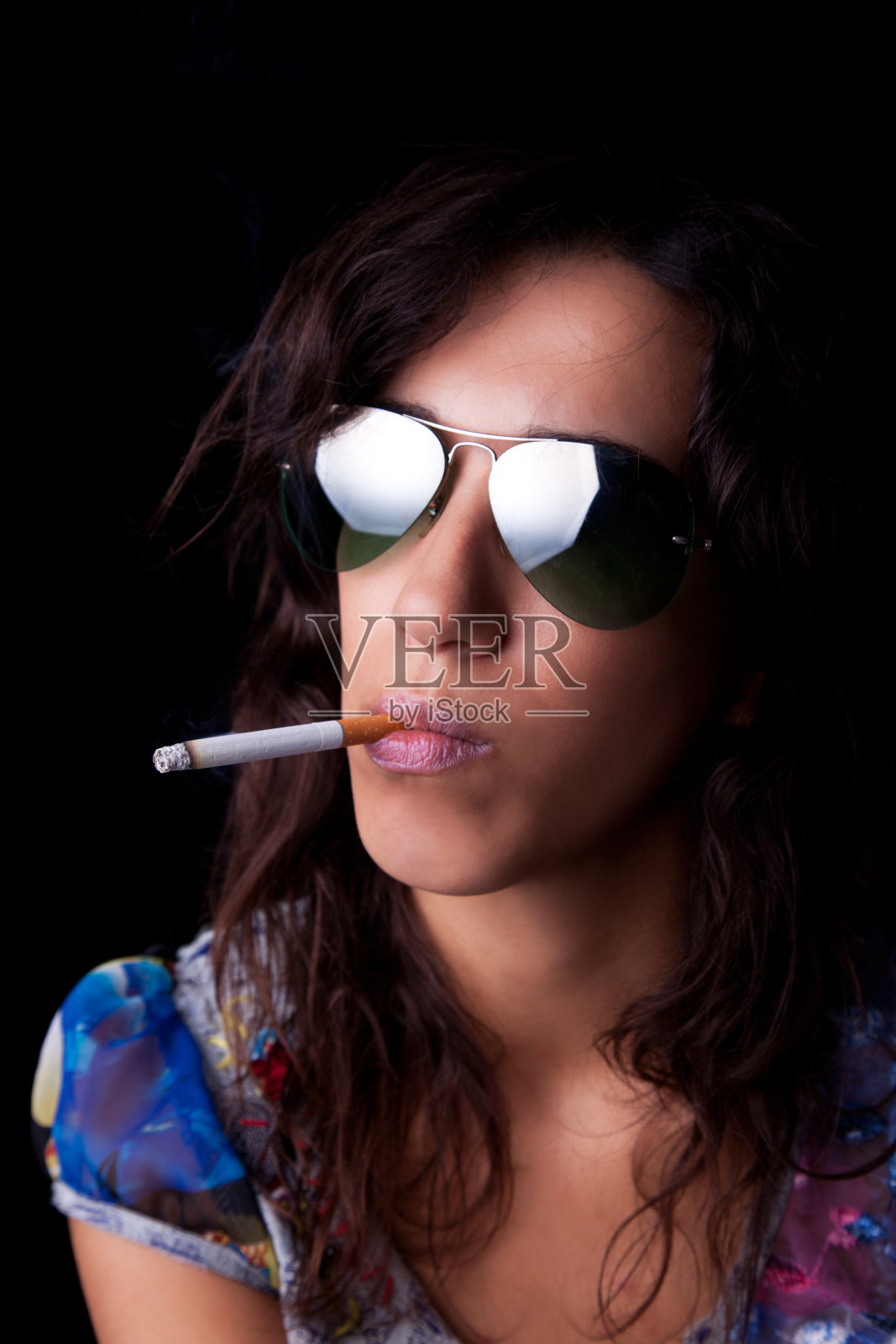 年轻性感的黑发女人,抽烟,戴着墨镜