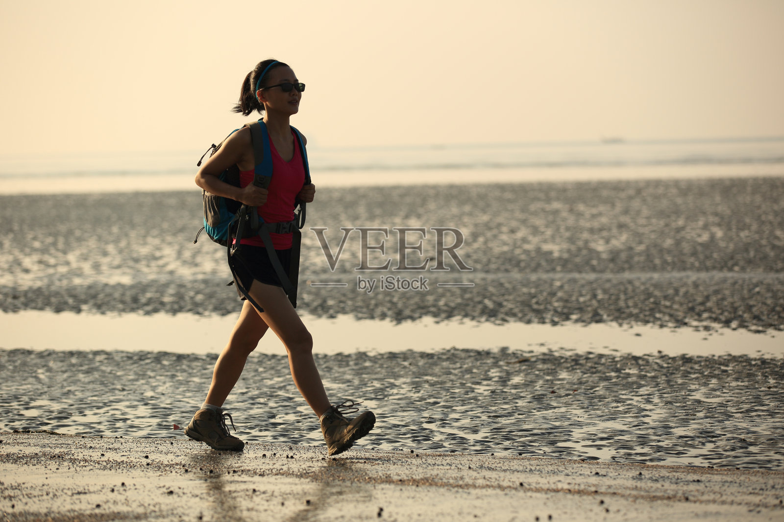 在日出海滩徒步旅行的年轻女子照片摄影图片
