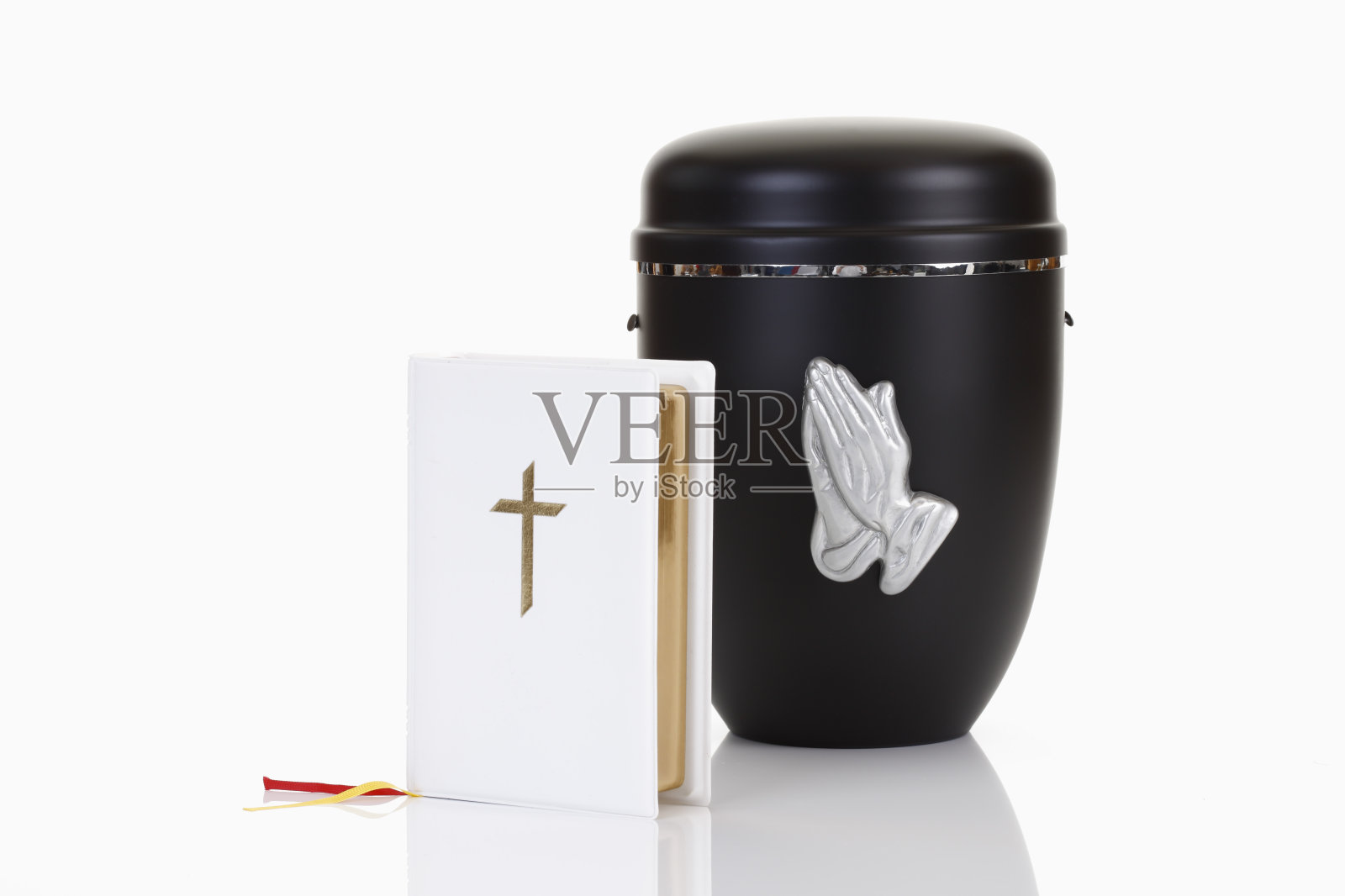 葬礼，装有祈祷手和白色圣经的骨灰瓮照片摄影图片