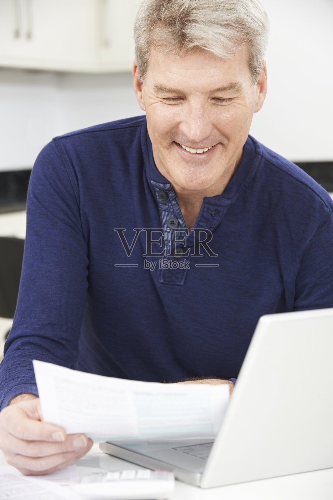 微笑的成熟男人审视家庭财务照片摄影图片