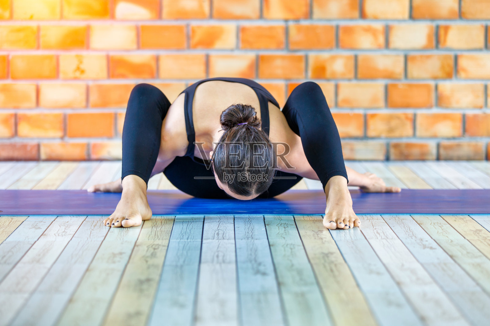 亚洲女性训练者在水泥背景中练习高难度瑜伽照片摄影图片