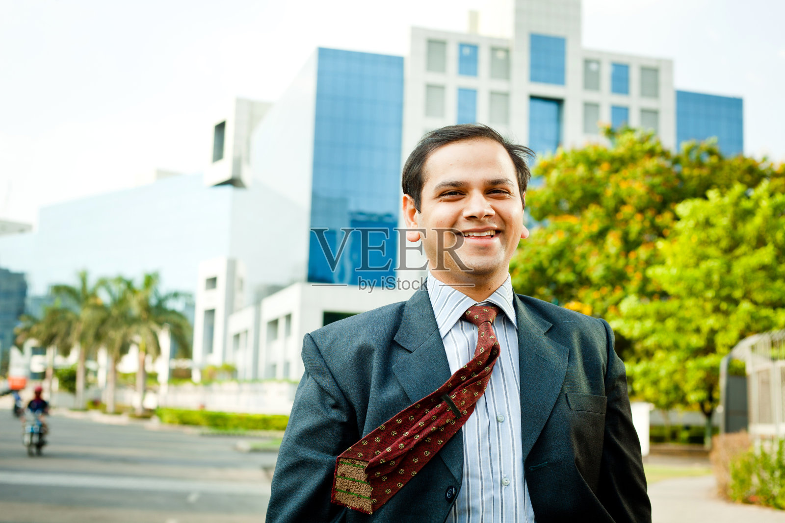 一位自信开朗的印度商人站在办公大楼前照片摄影图片